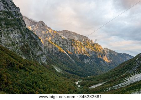 Morning Sun Illuminating A Lush Mountain Valley.
