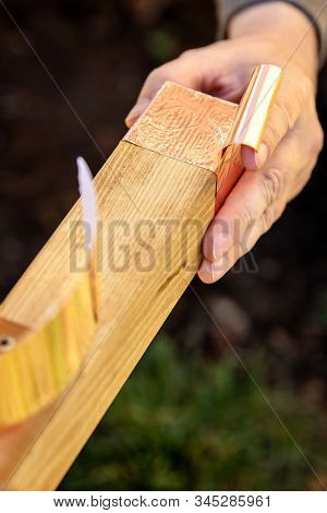Man Is Affixing A Copper Tape On Wooden Beam, Barrier And Protection For Slugs And Snails, Closeup