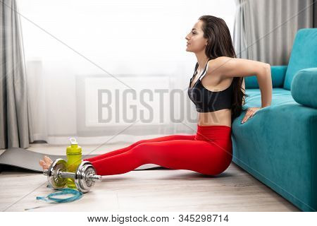 Fit Brunette Woman In Red Sport Leggings And Black Top Doing Everyday Warm Up Home Exercises On The 