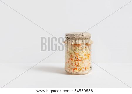 Homemade Sauerkraut. Fermented Food. Sauerkraut With Carrots In A Glass Jar On A White Wooden Backgr