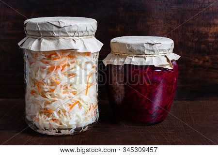 Homemade Sauerkraut With Carrots And Cabbage Salad With Beets In A Glass Jar On A Brown Wooden Backg