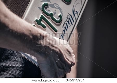American Car License Plate. State Of Illinois Dmv. Men With Plate In Hands Closeup Photo.
