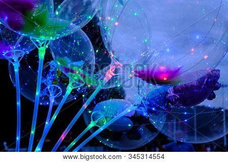 Defocused Image Of Neon Lights Of Illuminated Balloons Filled With Hellium With Led Light At Night