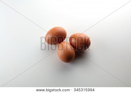 Brown egg on nuetral white background, Darkish tone. 