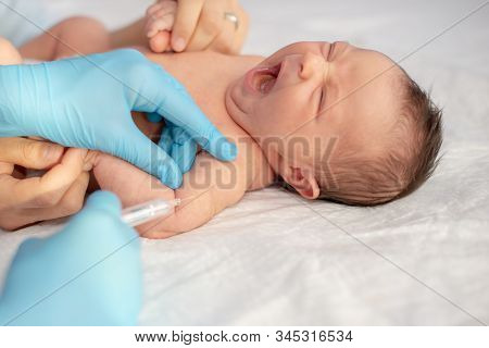 Pediatrician Vaccinating A Newborn Baby At Shoulder.