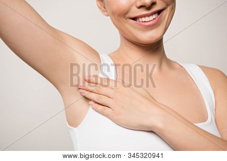 Partial View Of Smiling Woman Applying Deodorant On Underarm Isolated On Grey