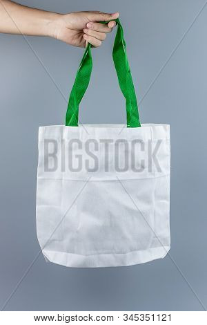 Man Holding Eco Shopping Bag On Gray Background With Copy Space For Text. Environmental Protection, 