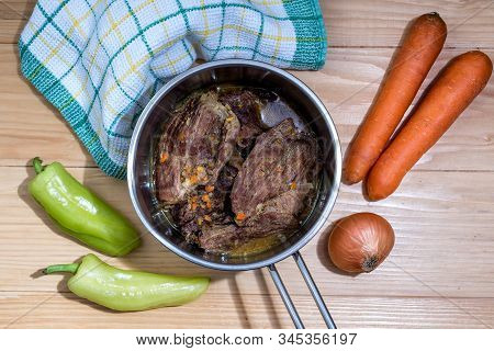 Traditionally Made Beef Steaks In Sauce With Carrots And Onions Offered As Closeup In A Cast Iron Sa