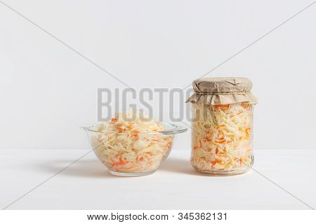 Homemade Sauerkraut. Fermented Food. Sauerkraut With Carrots In Glass Jar And Bowl With Fork On Wood