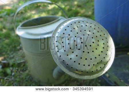 Close Up Of Old Metal Watering Can In The Garden