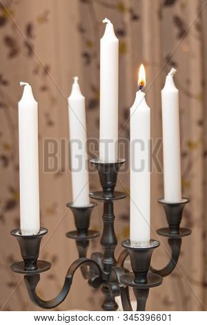 Burning Candles In Retro Candlestick Stands On Table In Room. Woman Hand Lights Candles. Romantic At