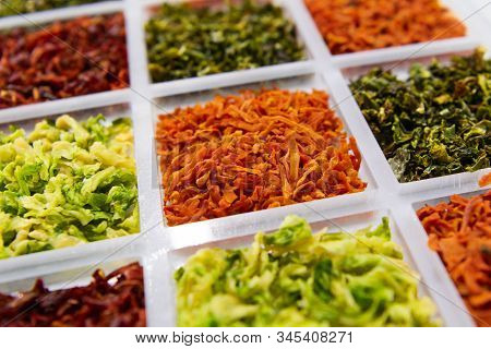 Sublimated Thinly Sliced Vegetables. Dried Carrots In The Center Of The Frame. In Neighboring Cells,