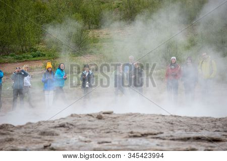 Tourists Visiting Strokkur Geyser In Iceland