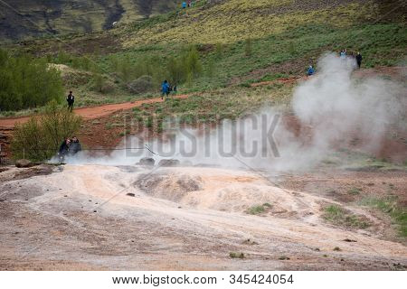 Tourists Visiting Strokkur Geyser In Iceland