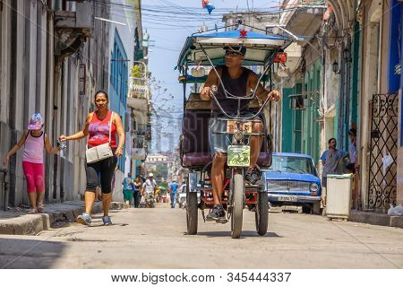 Havana, Cuba - May 16, 2019: Bicycle Taxi Driver In The Street Of Old Havana City During A Vibrant A