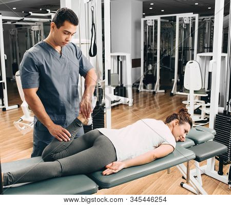 Kinesiologist Doing Therapeutic Exercises For A Woman. Kinesitherapy At The Medical Center