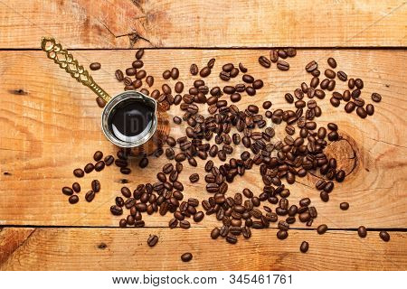 Turkish Coffee Maker And Coffee Grains On A Rustic Wooden Table