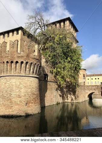 Castle In Fontanellato, Parma, Italy. Medieval Castle With Moat Across Trees And Blue Sky. Water Ref