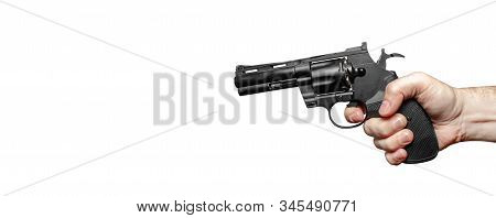 Male Hand With A Black Revolver Ready To Shoot. The Finger Presses The Trigger. Close-up. Isolate On