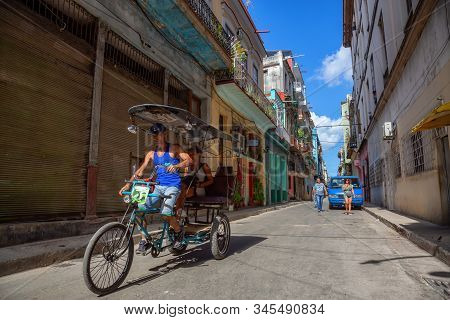 Havana, Cuba - May 13, 2019: Bicycle Taxi Driver Riding In The Streets Of Old Havana City During A V