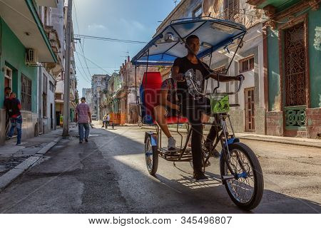 Havana, Cuba - May 13, 2019: Bicycle Taxi Driver Riding In The Streets Of Old Havana City During A V