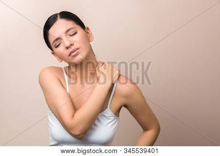 Beautiful Young Woman Has A Pain In The Neck. Studio Shoot Of Pain Expression