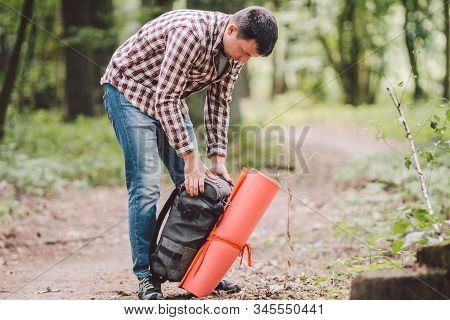 Hiker Holding His Camping Backpack. Traveler Opening Backpack While Traveling In Beautiful Wood. The
