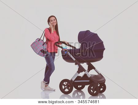 Full length portrait of a mother with a stroller, isolated on white background. Young mom