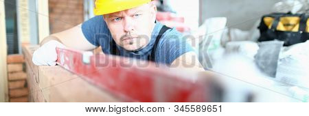 Portrait Of Bearded Builder Wearing Hard Gloves To Keep Hands Unharmed. Professional Man Using Speci