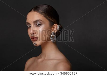 Portrait Of A Girl With Makeup, Pose In Profile With Bare Shoulders, Jewelry, Over Purpple Backgroun