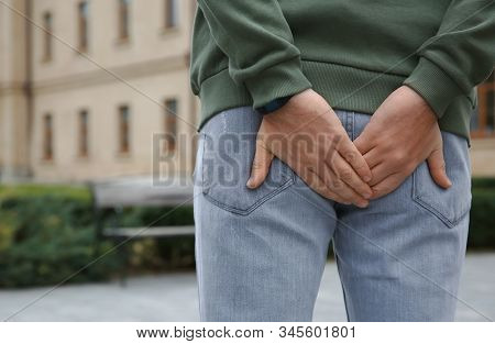 Man Suffering From Hemorrhoid Pain Outdoors, Back View