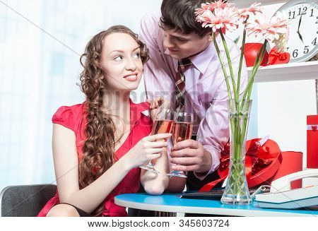 A Young Man, An Employee Of The Company Shows Courtship To His Colleague-a Young Woman With Curly Ha