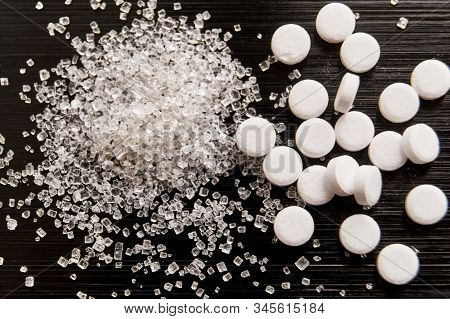 Sweetener Tablets Lying With Sugar On A Dark Background