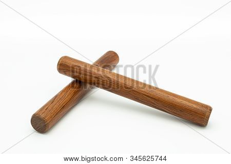 Closeup Of A Pair Of Wooden Claves Lying On A White Underground