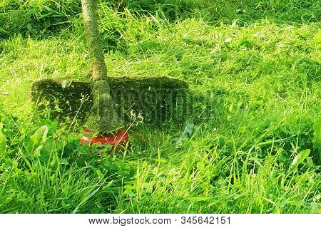 Mowing Green Wild Grass Field Using Brush Cutter Mower Or Power Tool String Lawn Trimmer. To Mow A G