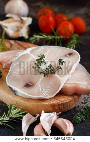 Two Shark Steak With Vegetables And Herbs On A Dark Board