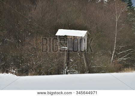 Wooden Hunting Lodge For Hunting In The Meadow In Winter