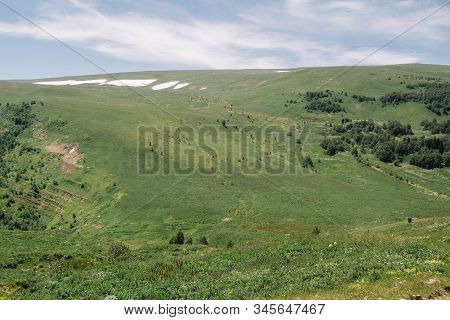 Summer View Of The Plateau Lago Naki With Snow. Beautiful Clouds And Mountain In A Blue Haze.