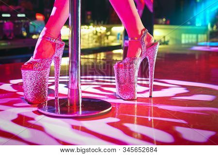 Young Sexy Woman Pole Dancing Striptease With Pylon In Night Club. Beautiful Stripper Girl On Stage.