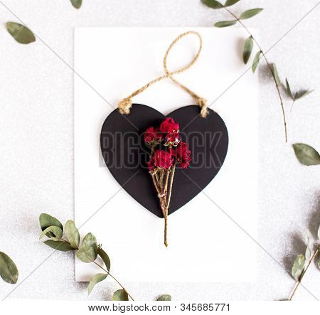 Background With Copy Space Blank On Table With Black Heart, Eucalyptus Branch, Roses Flowers And Lea