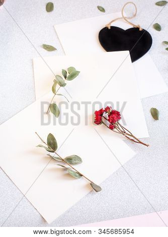 Background With Copy Space Blank On Table With Black Heart, Eucalyptus Branch, Roses Flowers And Lea