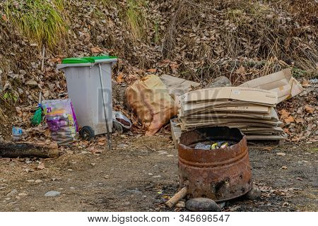 Cheonan, South Korea; January 12, 2020: Rusted Barrel Used For Burning Trash In Front Of Cardboard B