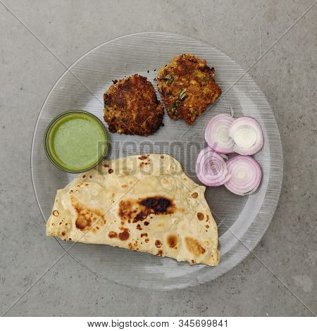 Hydrabadi Kawab Paratha With Green Chili Sauce & Onion On Transparent Plate. Kabab An Irani Dish Wit