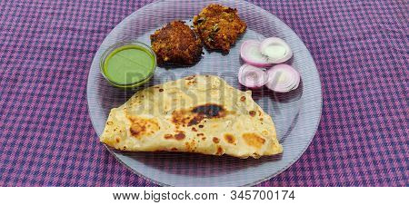 Hydrabadi Kawab Paratha With Green Chili Sauce & Onion On Transparent Plate. Kabab An Irani Dish Wit