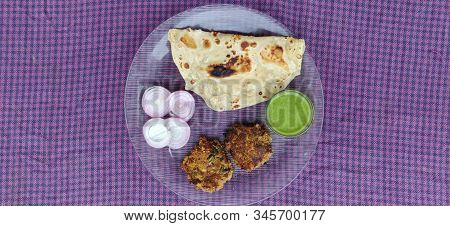 Hydrabadi Kawab Paratha With Green Chili Sauce & Onion On Transparent Plate. Kabab An Irani Dish Wit