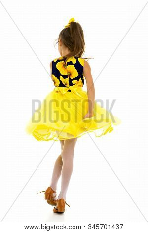 Happy Little Girl In A Lush Flowing Dress, Spinning. Her Hair Is Flying In The Wind. The Concept Of 