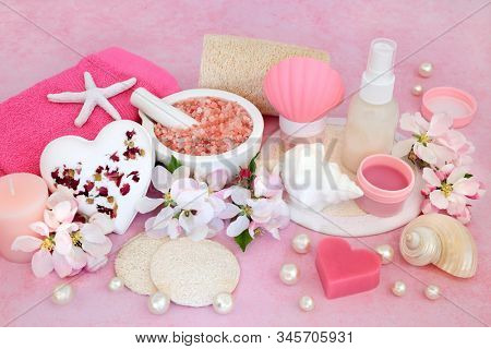 Beauty treatment for skincare with ex foliation mineral Himalayan salts, cleansing products and apple blossom flowers on pink background.round.