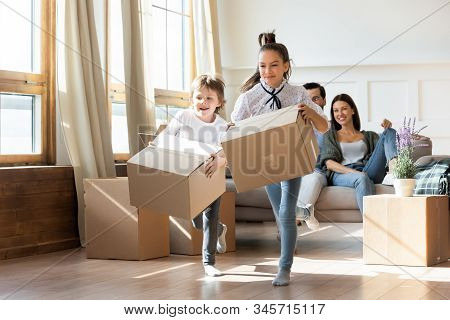 Excited Kids Have Fun Unpacking Boxes On Moving Day