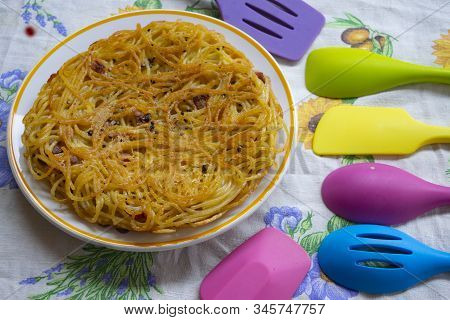 Spaghetti Frittata In A Dish Near Colored Dippers