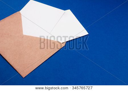 Envelope With White Paper Sheet Letter Flat Lay On Trendy Colorful Blue Background. Top View With Co